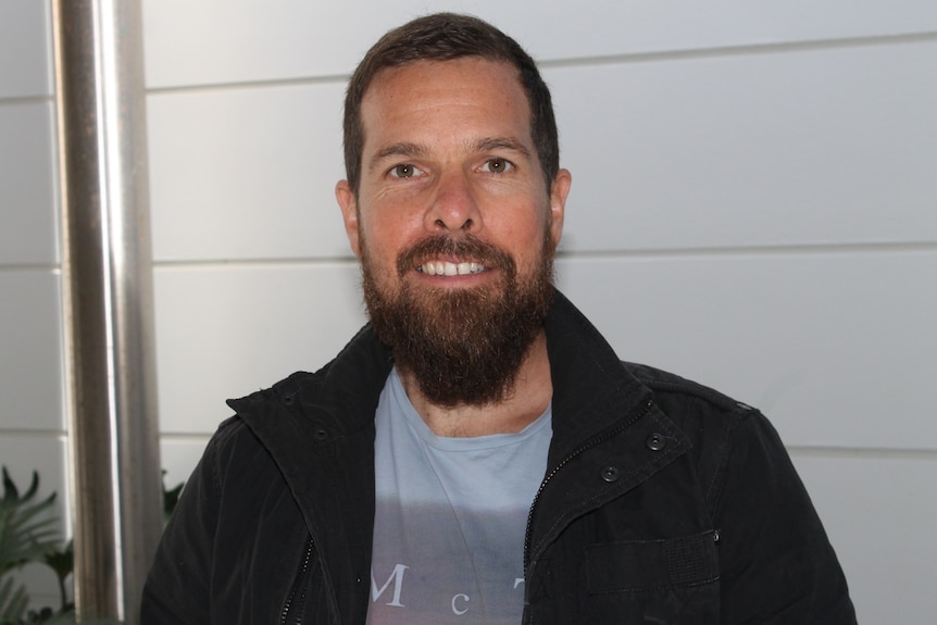 A man with a beard smiling