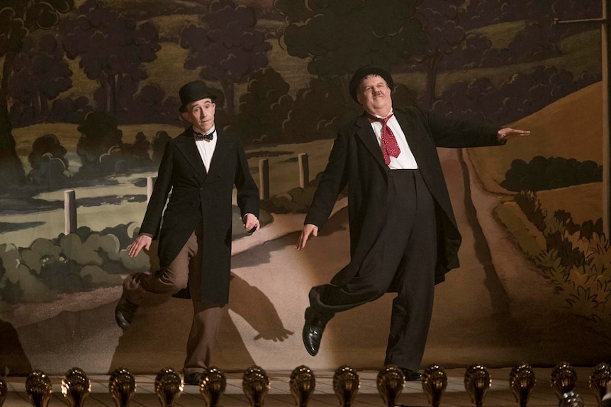 Colour still of Steve Coogan and John C. Reilly on stage in 2018 film Stan and Ollie.