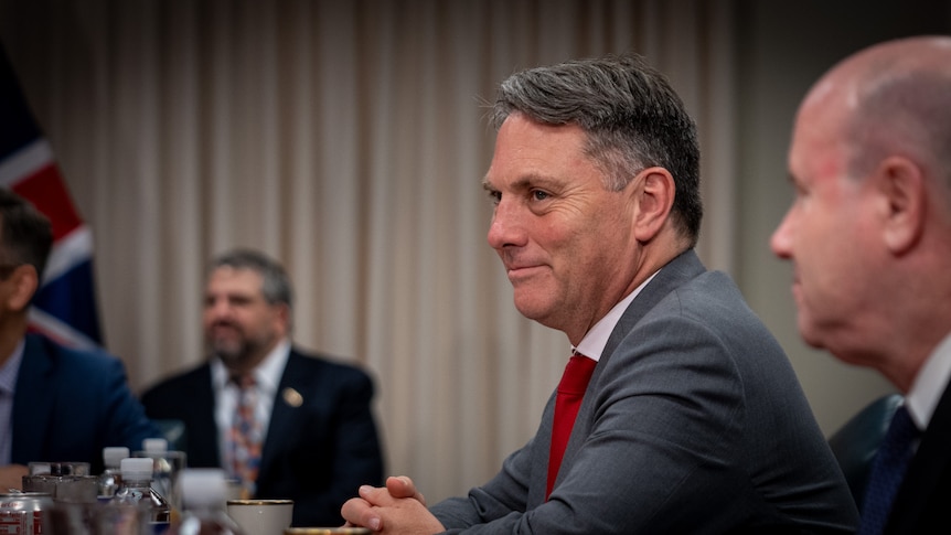 Richard Marles sitting at a table smiling 