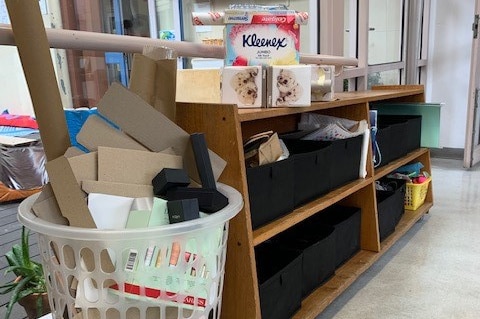 A washing basket filled with cardboard of different shapes and sizes.