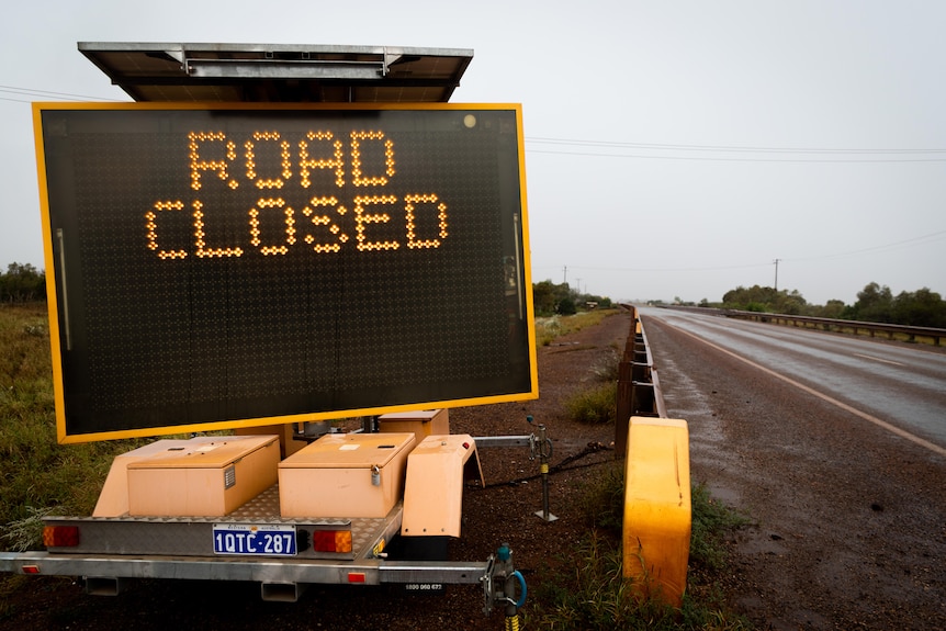 A road closed sign on the side of a rural highway