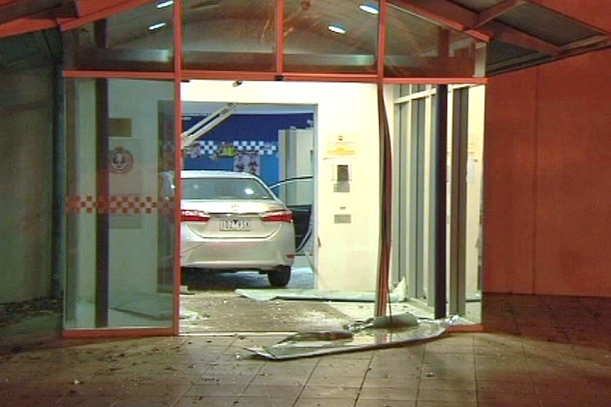 A car sits inside the lobby of a police station.