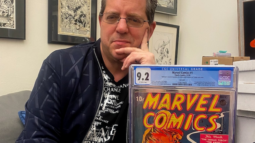 Man smiles holding Marvel comic 1 in case