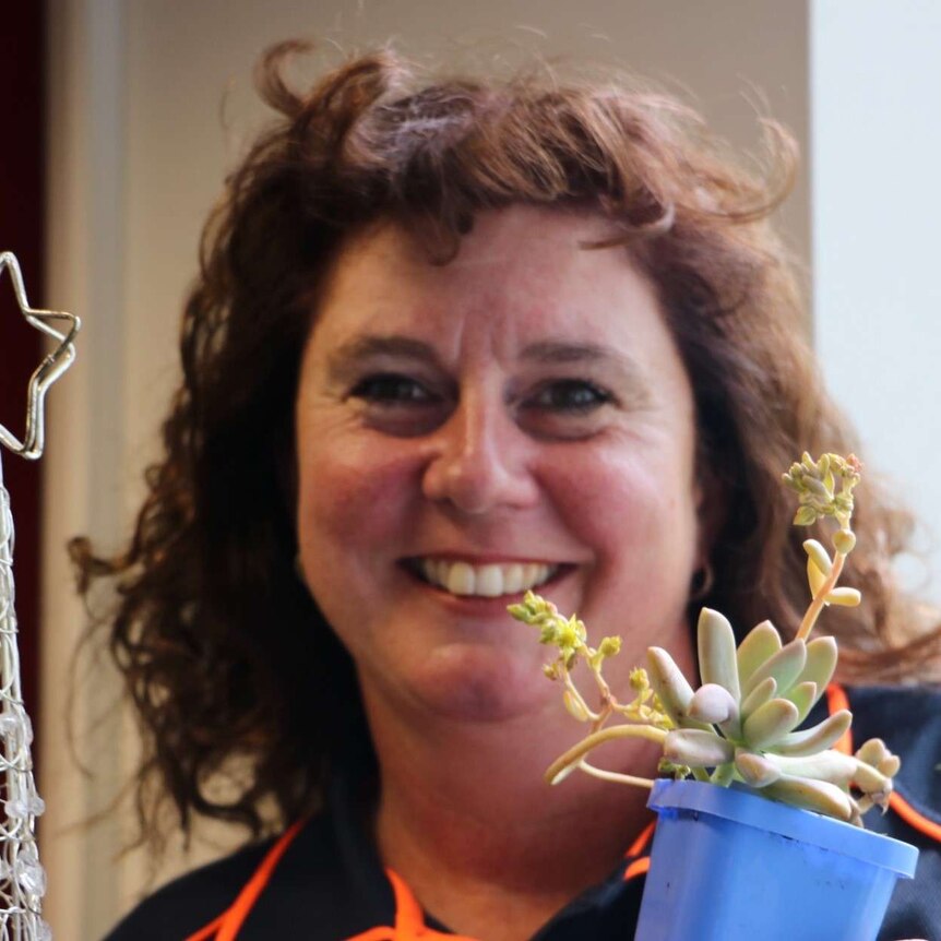 Canberra succulent expert Jackie Warburton holding plant and Christmas trellis.