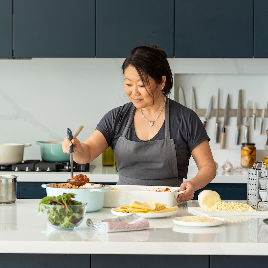 Nagi Maehashi wearing an apron preparing food in her kitchen