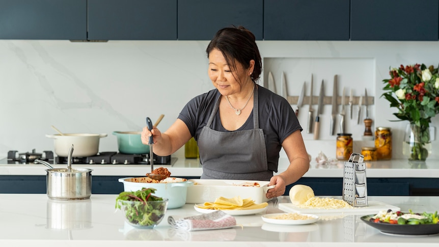 Nagi Maehashi wearing an apron preparing food in her kitchen