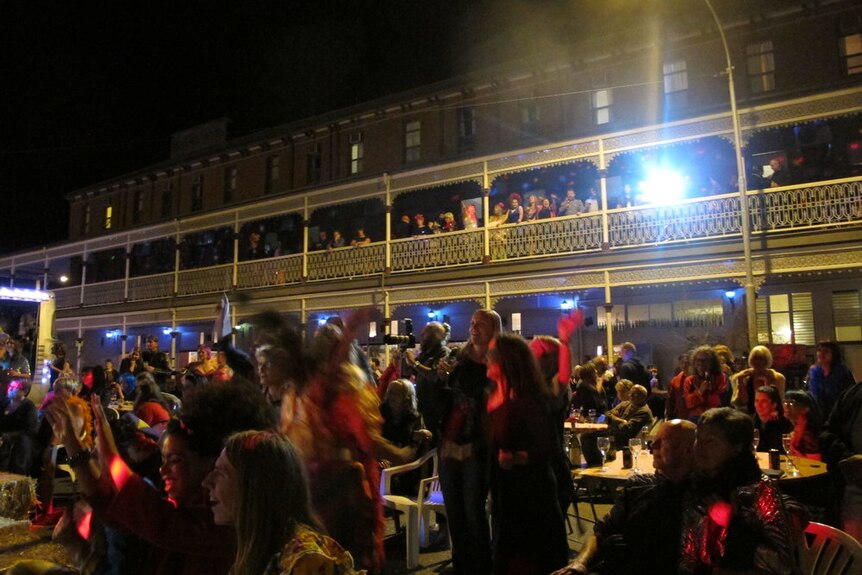 Outside the Palace Hotel Broken Hill by night filled with hundreds of people.