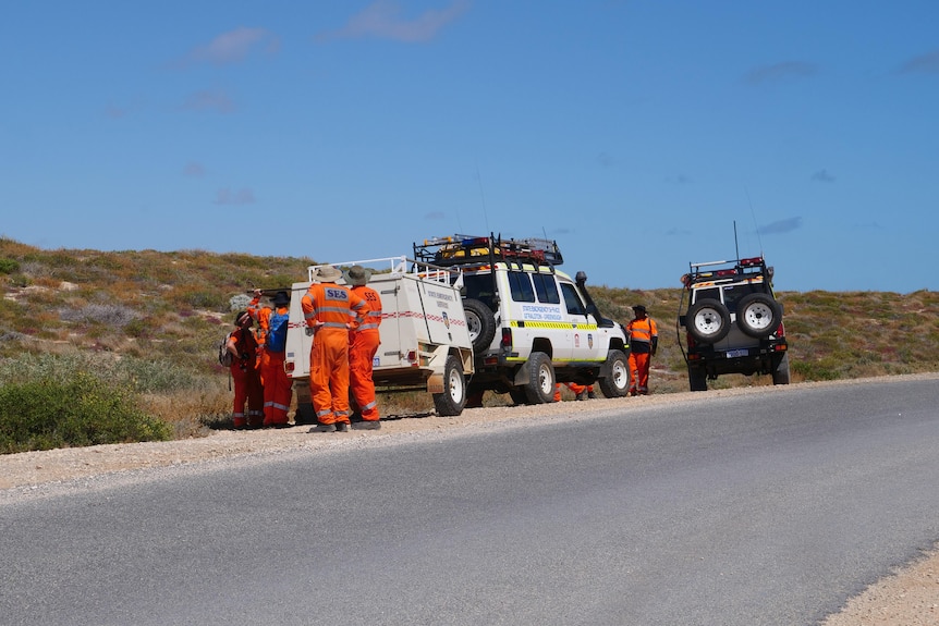 SES volunteers and vehicles on the side of a rural road.