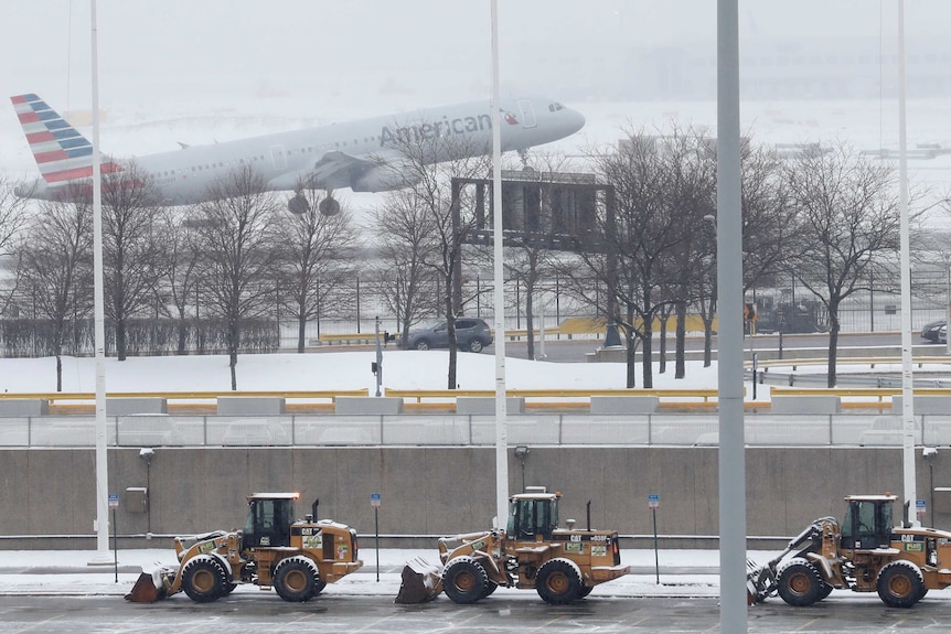 In this file photo, an American Airline plane takes off in heavy snow.