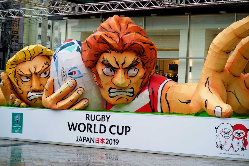 Giant street art depicts two rugby players, one holding the ball.