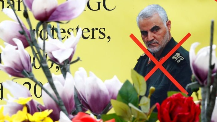 An Image of Iranian General Qassem Soleimani on a banner with an red  x marked over his body.