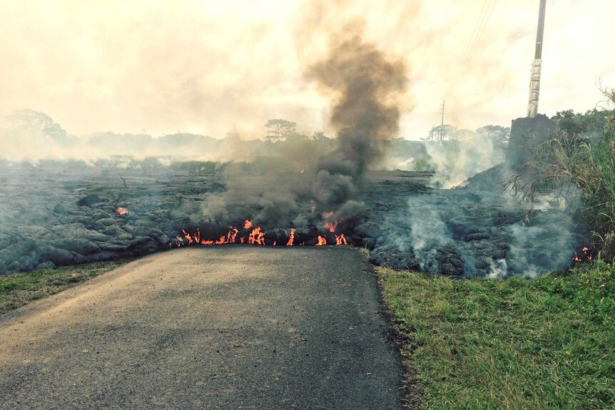 The lava flow from the Kilauea Volcano moves down a street near the village of Pahoa.