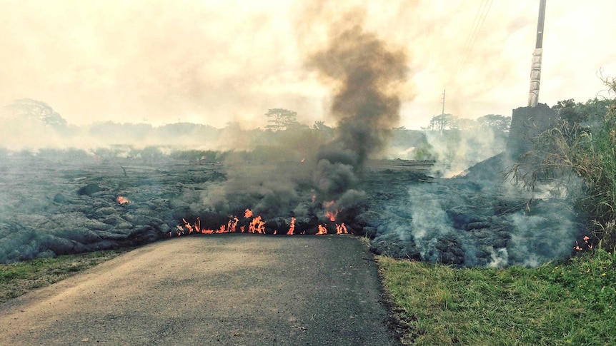 The lava flow from the Kilauea Volcano moves down a street near the village of Pahoa.