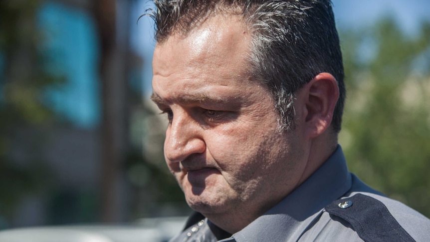 Highway Patrol trooper Travis Smaka holds back tears