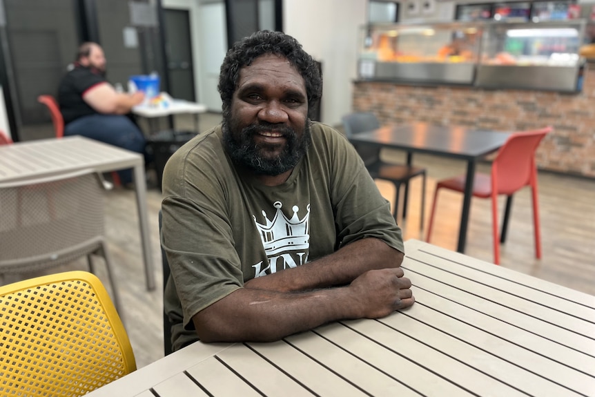an aboriginal man smiling at a table