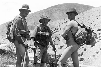 A black-and-white image of mountaineers, with one of them in the nude