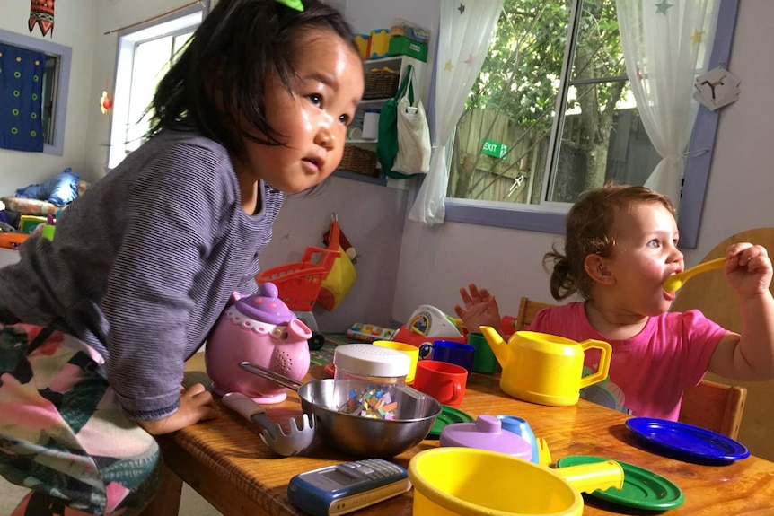 Two children playing on the ground.