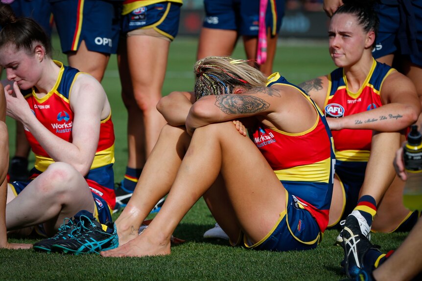 Adelaide Crows AFLw players look dejected after their grand final loss to the Brisbane Lions.