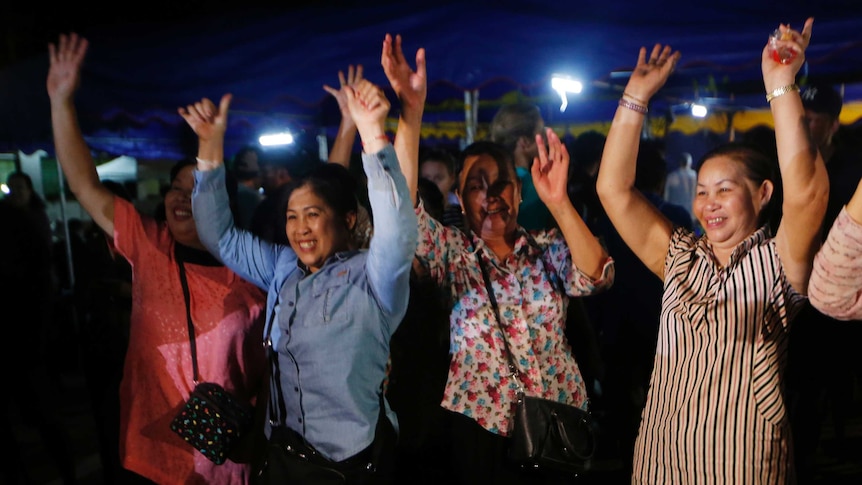 People put their hands in the air to celebrate news of boys being rescued from a cave in Thailand.