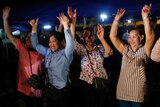 People put their hands in the air to celebrate news of boys being rescued from a cave in Thailand.
