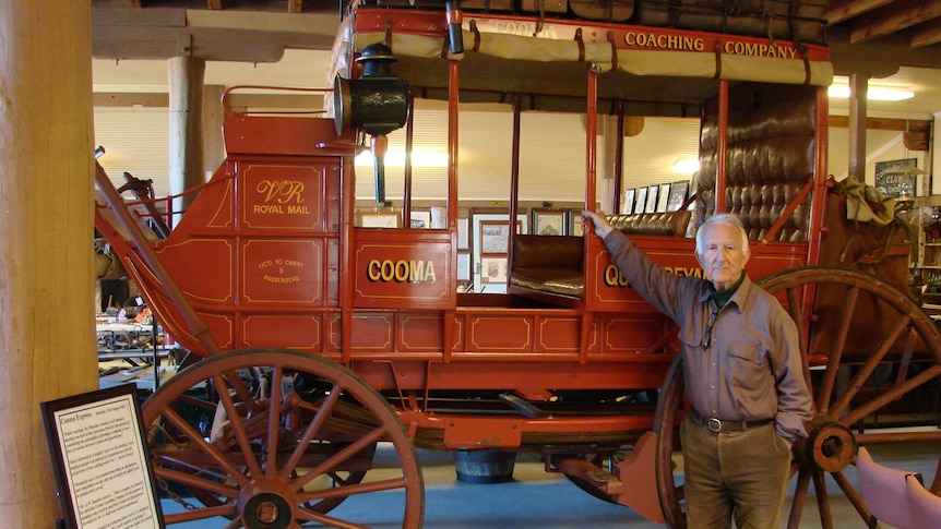 Neville Locker standing in front of old horse drawn coach
