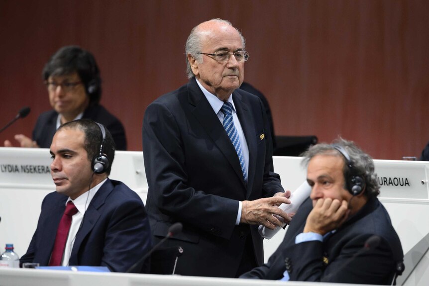 Sepp Blatter walks past Prince Ali and Michel Platini