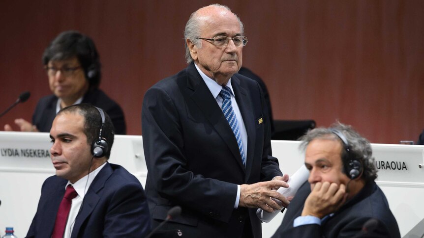 Sepp Blatter walks past Prince Ali and Michel Platini