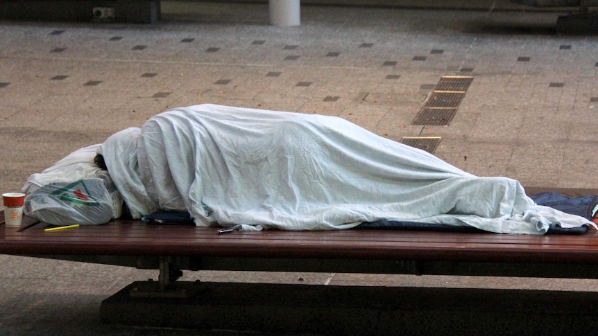 Homeless person sleeping on a bench