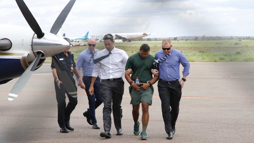 NT Police escort Jermaine Austral off a flight after he was extradited from Broken Hill to Alice Springs