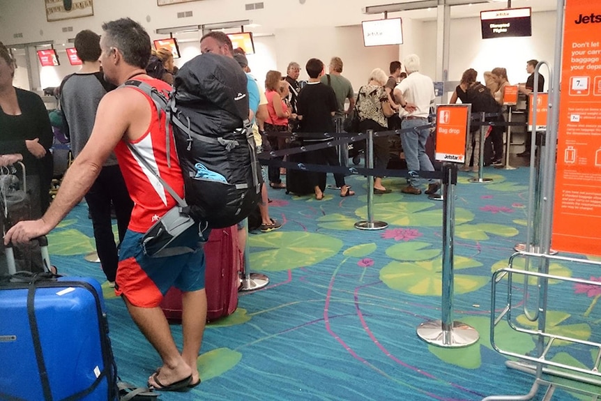 Passengers due to go to Bali queue up at Darwin International Airport