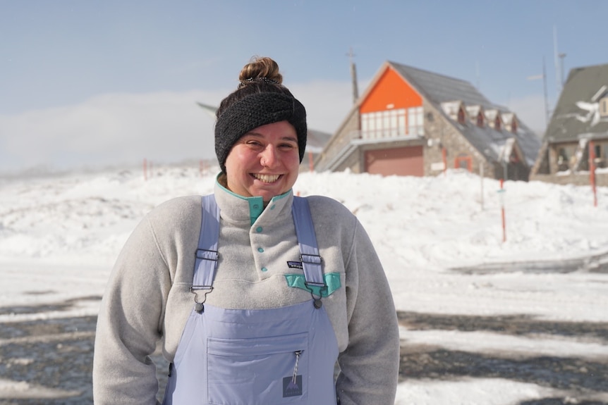 A woman in a beanie and snow gear smiling