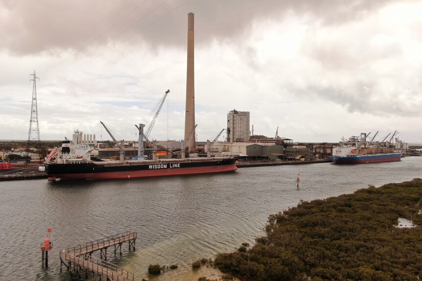 A ship beside a lead smelter on a river