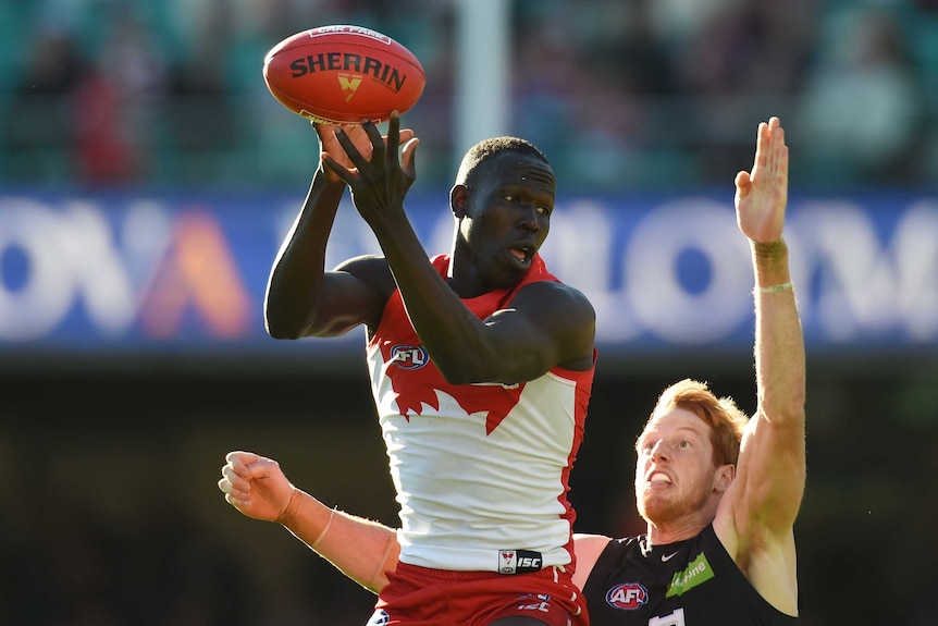Sydney's Aliir Aliir competes for the ball with Carlton's Andrew Phillips at SCG in July 2016.