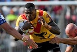 Kato Ottio of Papua New Guinea is seen from front-on being tackled by two players.