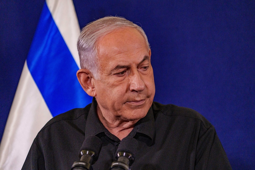 Benjamin Netanyahu in front of an Israeli flag 