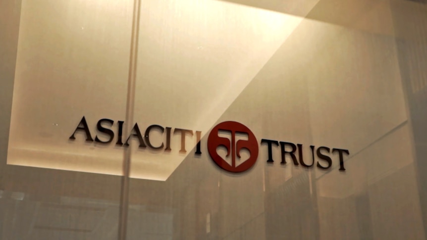 A logo and sign on a wall that says "Asiaciti Trust". The photo has been taken through a glass door.