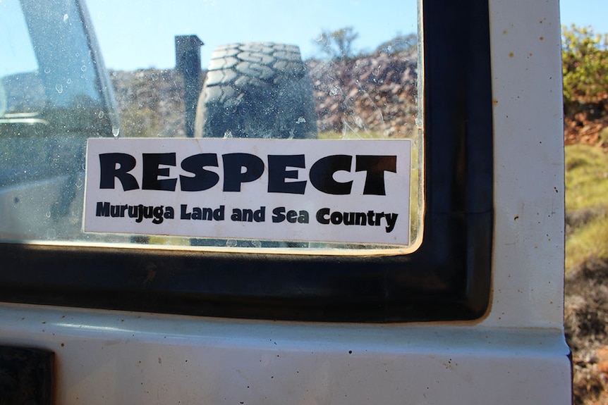 A sticker saying 'Respect Murujuga Land and Sea Country' on the back of a Murujuga ranger car window.