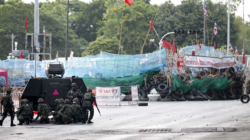 Thai troops and armoured vehicles take up their positions on a deserted road