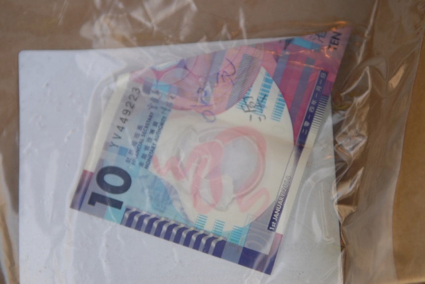 A bank note in a plastic evidence bag.