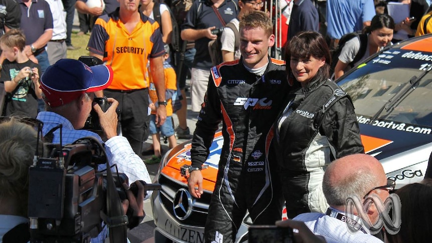 Townsville Mayor Jenny Hill stands with racecar driver Maro Engel in front of a racing car in 2013.