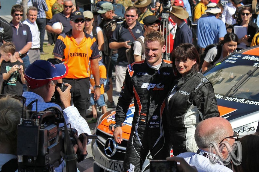 Townsville Mayor Jenny Hill stands with racecar driver Maro Engel in front of a racing car in 2013.