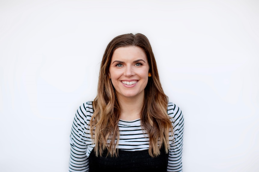 A smiling woman looks into the camera. 