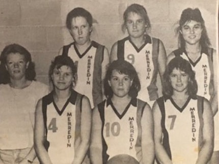 black and white newspaper clipping of six girls in basketball uniforms with their coach 