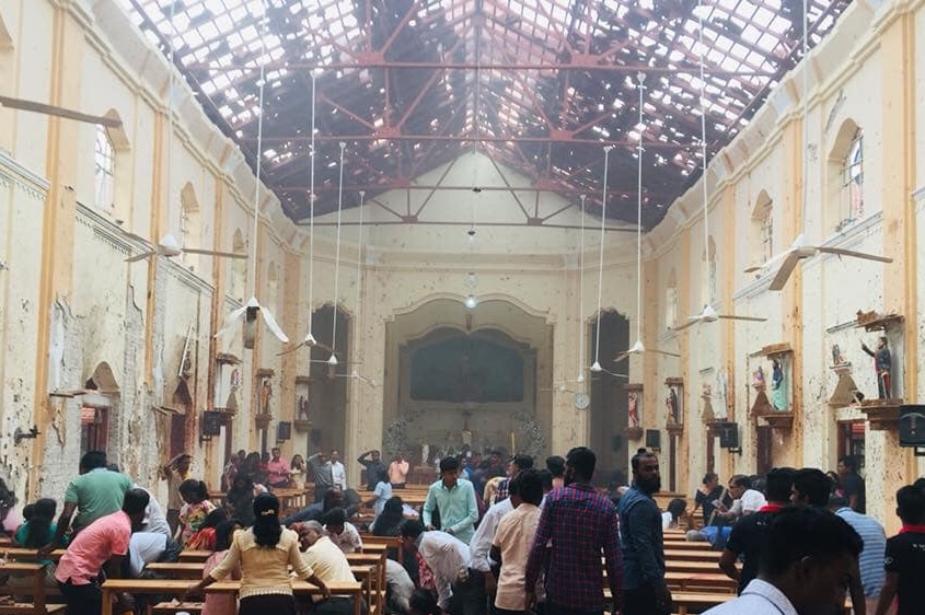 A crowded hall with a missing roof.