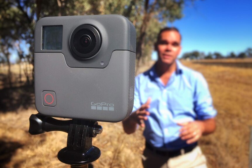 GoPro 360 camera with Clarke in background near railway tracks.