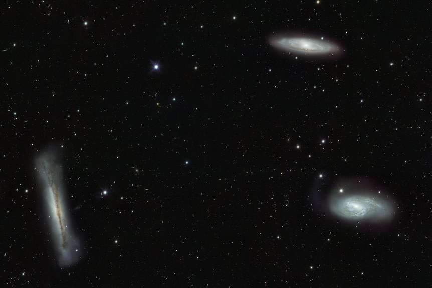 Three galaxies amid stars.