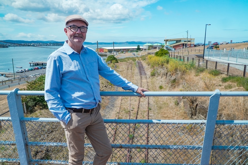 John Kelly, former owner of the state cinema, smiles as he stands next to a tram track.