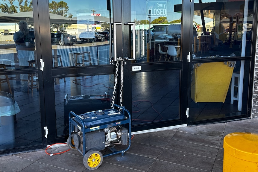 A generator chained to the front of a shop