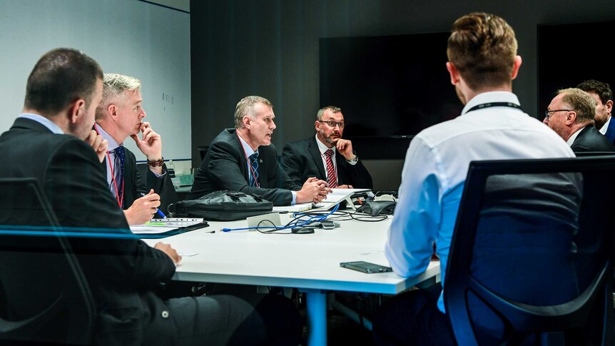 AFP Police officers are seen sitting with ABC Lawyers in a meeting room.