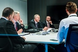 AFP Police officers are seen sitting with ABC Lawyers in a meeting room.